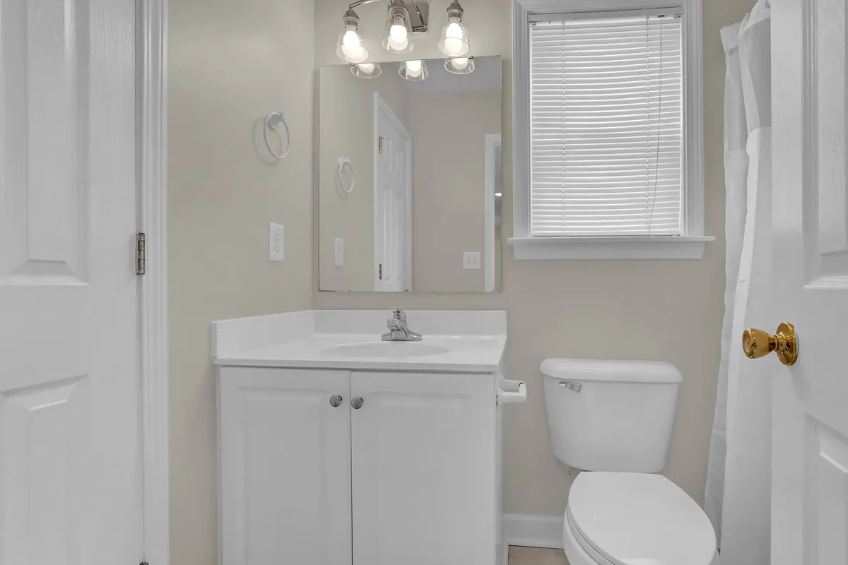 A bright, inviting vanity area with a large sink, expansive mirror, and stylish lighting fixtures. The modern and clean design suggests a welcoming environment for guests' daily routines.
