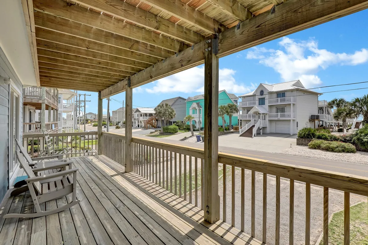 This image shows a wooden deck with an expansive ocean view, offering a natural extension to the indoor gathering spaces. The scene encourages enjoying the sights and sounds of the sea, whether alone with a morning coffee or together with family and friends.