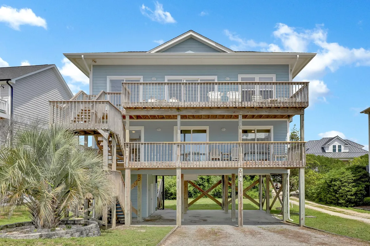An inviting, spacious deck framed by palm trees and an open layout, perfect for outdoor dining or relaxing. The deck is staged for group gatherings, with plenty of room for family members of all generations to enjoy the fresh air and views.